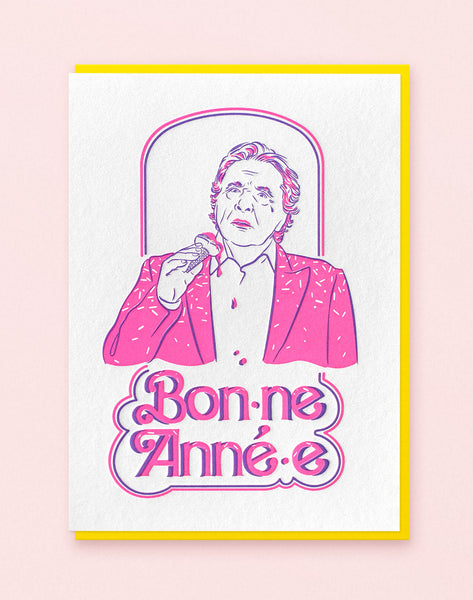Carte voeux imprimée en letterpress deux couleurs rose fluo et violet, créee par Cécile Alvarez représentant Michel Sardou sur le theme de l'écriture inclusive. Livrée avec une enveloppe jaune vif.